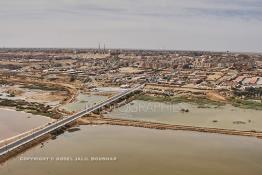 Image du Maroc Professionnelle de  Cette vue aérienne de la ville de Laayoune nous découvre au premier plan le fleuve la Sakia Al Hamra juste derrière protégé par une digue la partie stagnante des égouts à ciel ouvert, malgré tous les investissements la ville manque cruellement d'une station de pompage et d'une station de traitement des eaux usées, le 9 Avril 2010. (Photo / Abdeljalil Bounhar) 